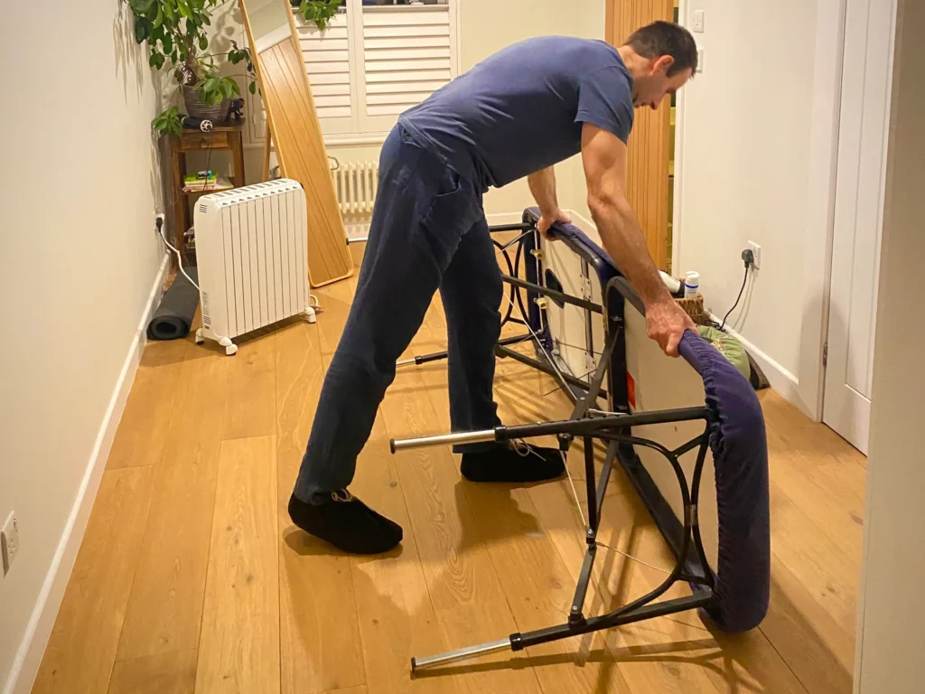 Mobile massage therapist is getting ready for a Sports massage treatment by setting up the table.